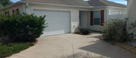 A single-story house with a garage, a front porch, and a driveway.