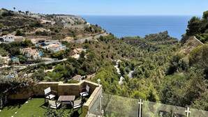 A coastal view with a patio area featuring outdoor furniture. - Villa Camelia - Benitachell, Costa Blanca (Benitachell)