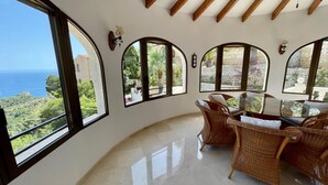 A spacious room with large windows offering a view of the sea and greenery. - Villa Camelia - Benitachell, Costa Blanca (Benitachell)