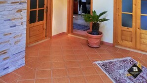 A spacious interior with a high ceiling, a wooden staircase, and a view of a dining area. - Casa Lacry (Manastirea Humorului)