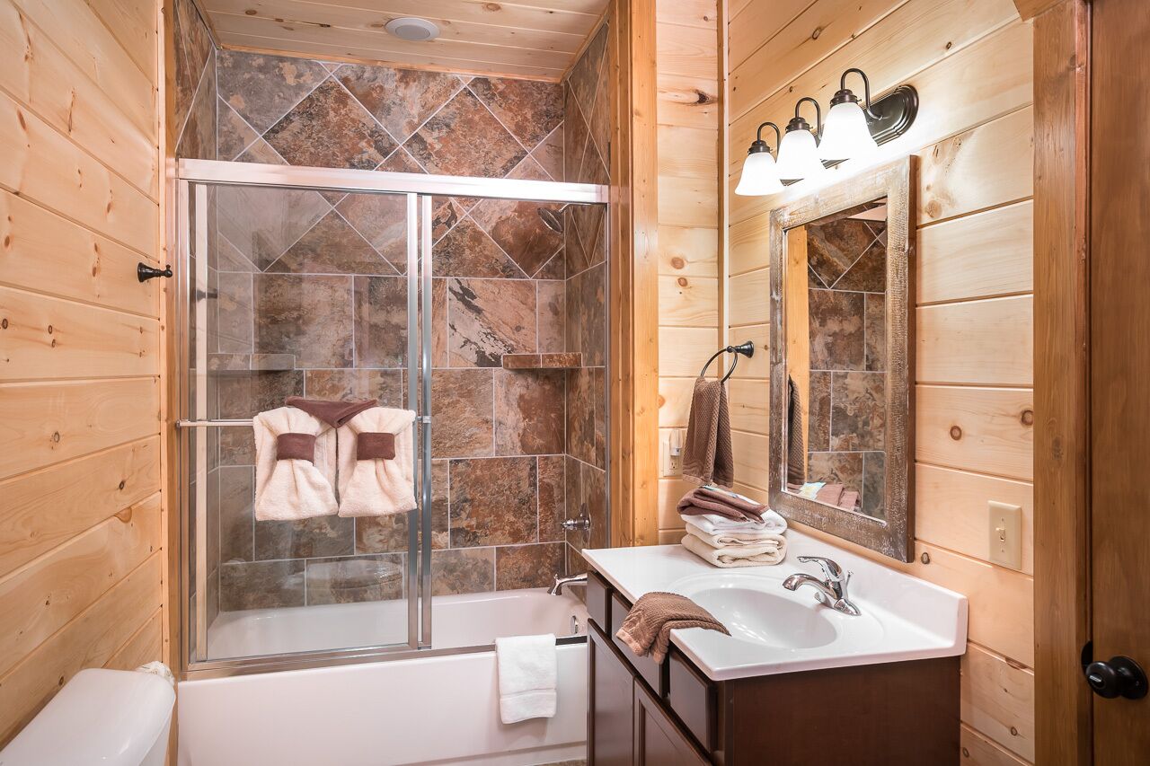 A bathroom with a glass shower enclosure, a bathtub, and a vanity with a mirror.