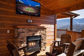 Relax in a warm, inviting space with a stone fireplace, flat-screen TV, and comfortable seating.