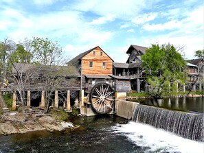 Situated by a serene body of water, this historic building features a traditional wooden facade and a prominent water wheel.