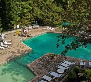 Relax by the serene pool surrounded by lush greenery and lounge under shaded areas.