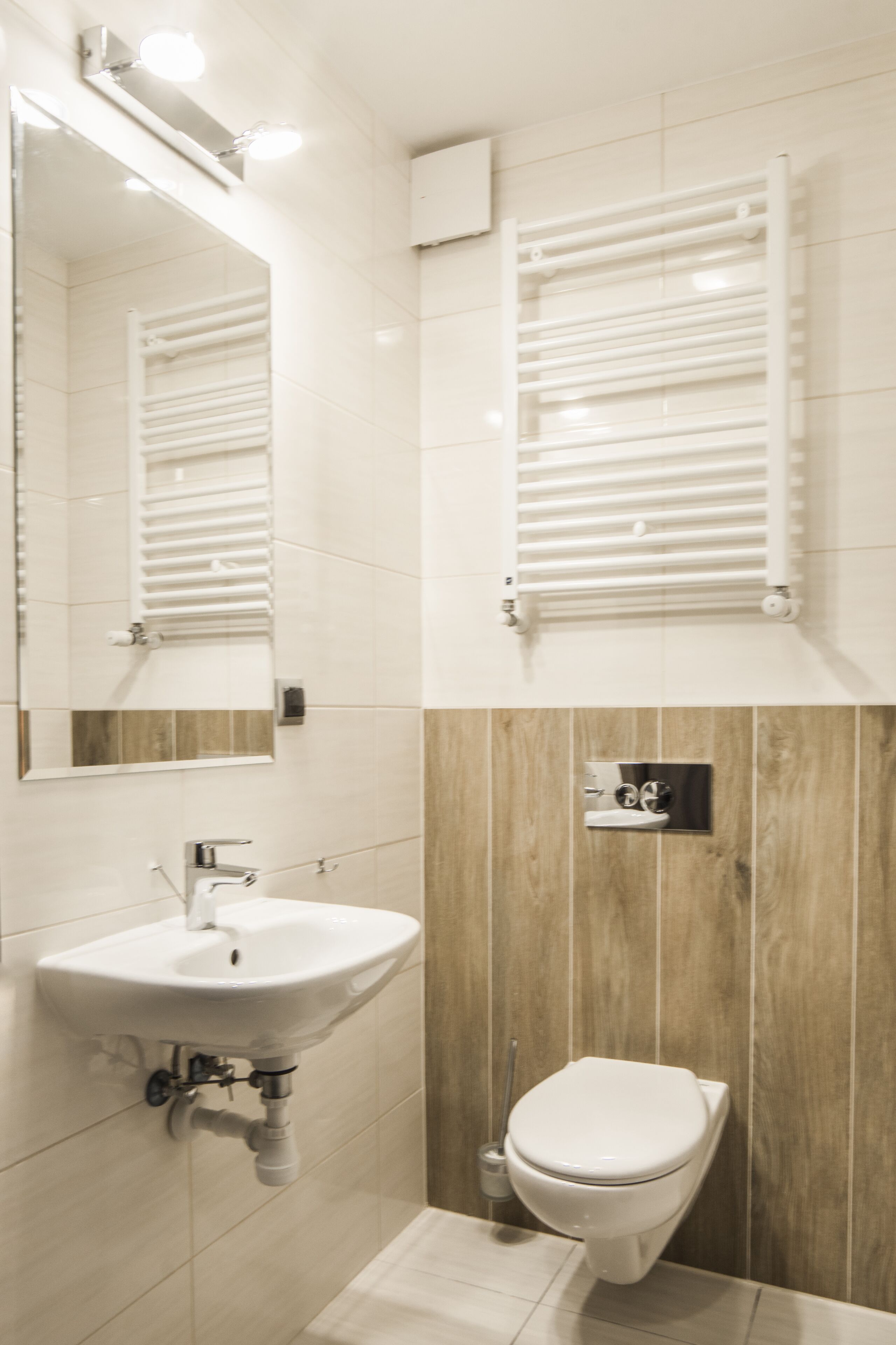 Ein modernes Badezimmer mit Waschbecken, Toilette und Spiegel.