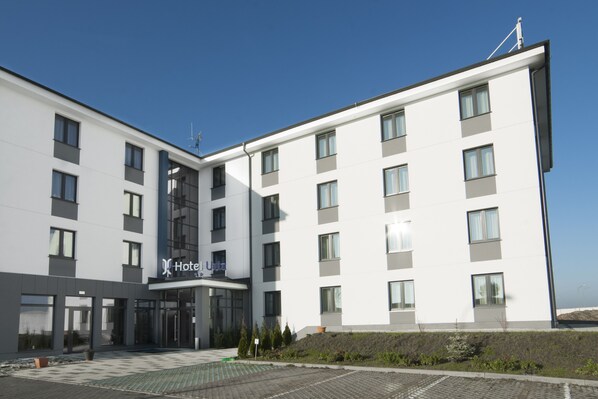 A modern hotel building with a flat facade, multiple windows, and a visible entrance. - Hotel Urbi (Gdansk)