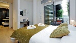 Une chambre d’hôtel moderne dotée d’un grand lit, d’un bureau et d’un balcon avec vue.