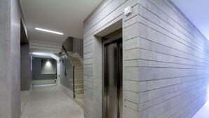 Un couloir moderne doté d’un ascenseur intégré et d’un escalier.
