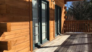 A wooden cabin with a covered porch and large windows.