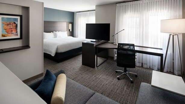 A hotel room with a bed, a desk with a TV, a chair, a lamp, and a couch. - Residence Inn by Marriott Nashville Mt. Juliet (Mount Juliet)
