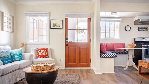 Un salon confortable avec un canapé, une table basse et une porte donnant sur une autre pièce.
