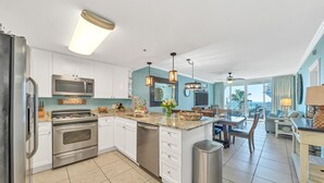 Una cocina moderna con armarios blancos, electrodomésticos de acero inoxidable y una isla central.