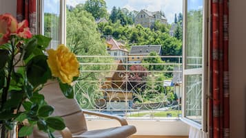 Ein Zimmer mit einem großen Fenster, einem Stuhl, einem Tisch und einem Buch.
