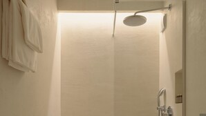 Een compacte, moderne badkamer met een douche, toilet en spiegel.