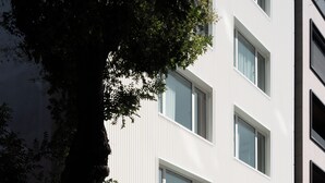Een modern hotelgebouw met grote ramen en een bord waarop staat 'HOTEL HELLO PLOVIDON'.