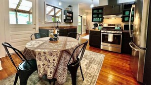 A modern kitchen with a dining area, featuring a round table, chairs, and a built-in oven.