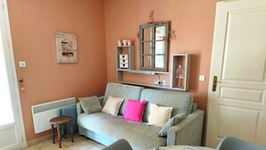 Ein Wohnzimmer mit einer Couch, einem kleinen Tisch und einer Heizung.