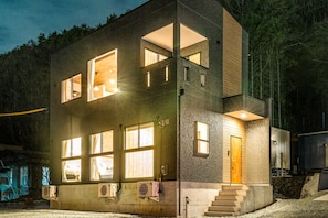 Vista frontal de la propiedad por la tarde o noche