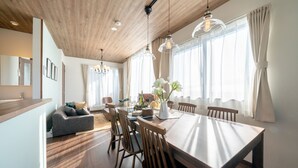 Un comedor moderno con una mesa de madera, sillas e iluminación colgante.
