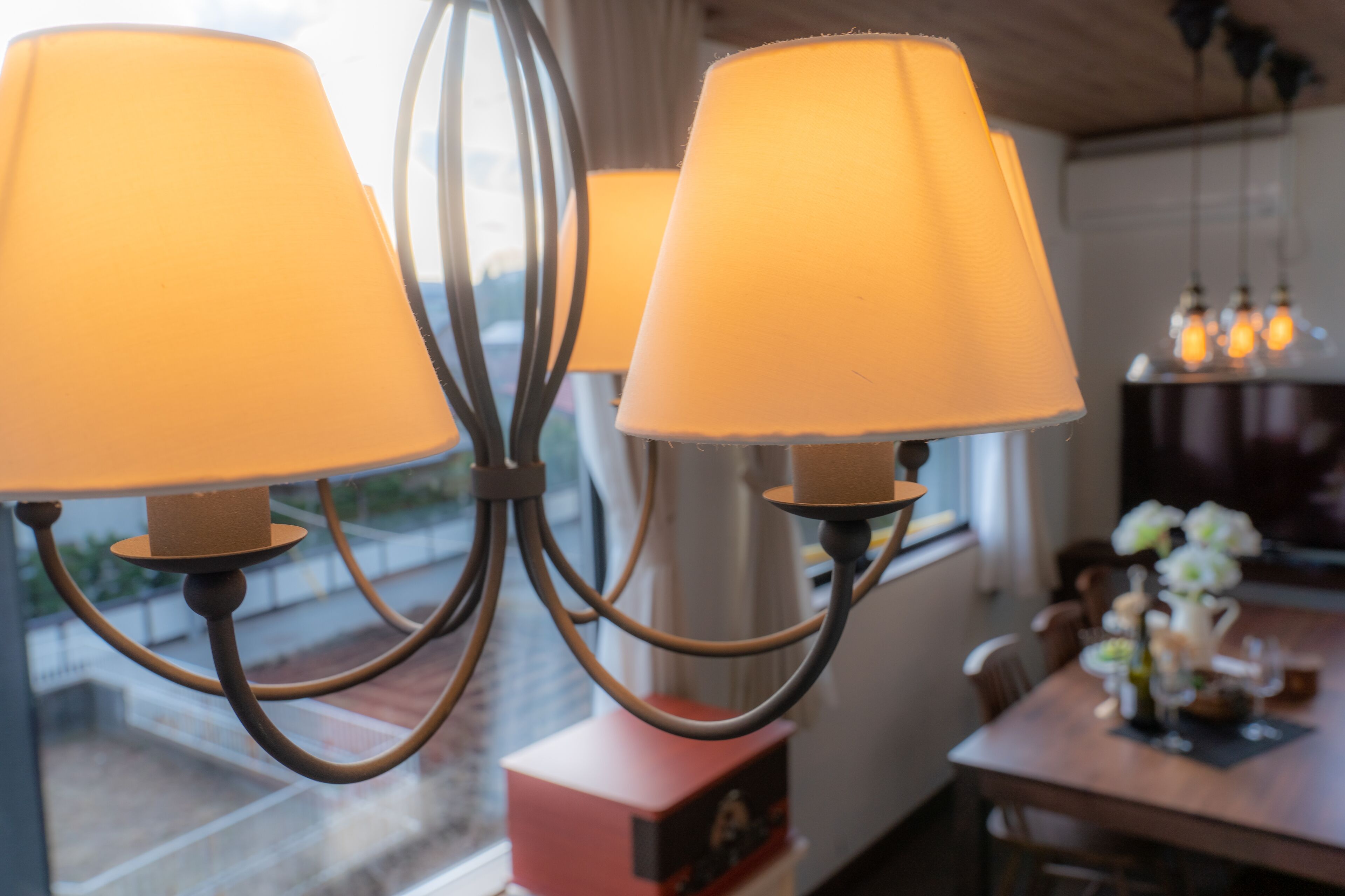 A chandelier with multiple lampshades in a dining area.