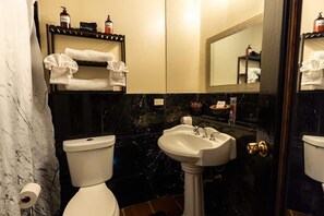 Une salle de bain équipée de toilettes, d’un lavabo et d’un porte-serviettes.