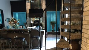 A modern living room with a staircase, a dining area, and a kitchen. - Spacious, clean, comfortable home that's relaxing with a warm feeling.<br> (San Antonio)