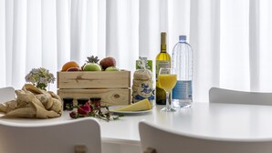 Ein Esstisch mit verschiedenen Speisen, darunter Obst, Brot, Käse und einer Wasserflasche.