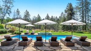 A poolside area with lounge chairs and umbrellas, surrounded by a landscaped garden and tall trees. - Relax in the most beautiful, secluded setting Sonoma County has to offer (Santa Rosa)