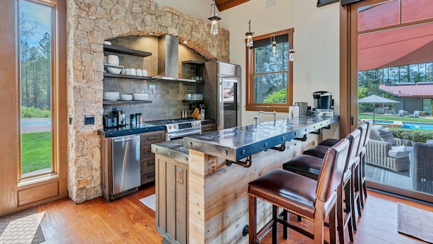 A modern kitchen with a stone arch, stainless steel appliances, and a bar area with seating. - Relax in the most beautiful, secluded setting Sonoma County has to offer (Santa Rosa)