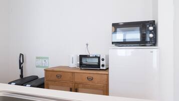 A kitchenette with a microwave, toaster oven, and a refrigerator.