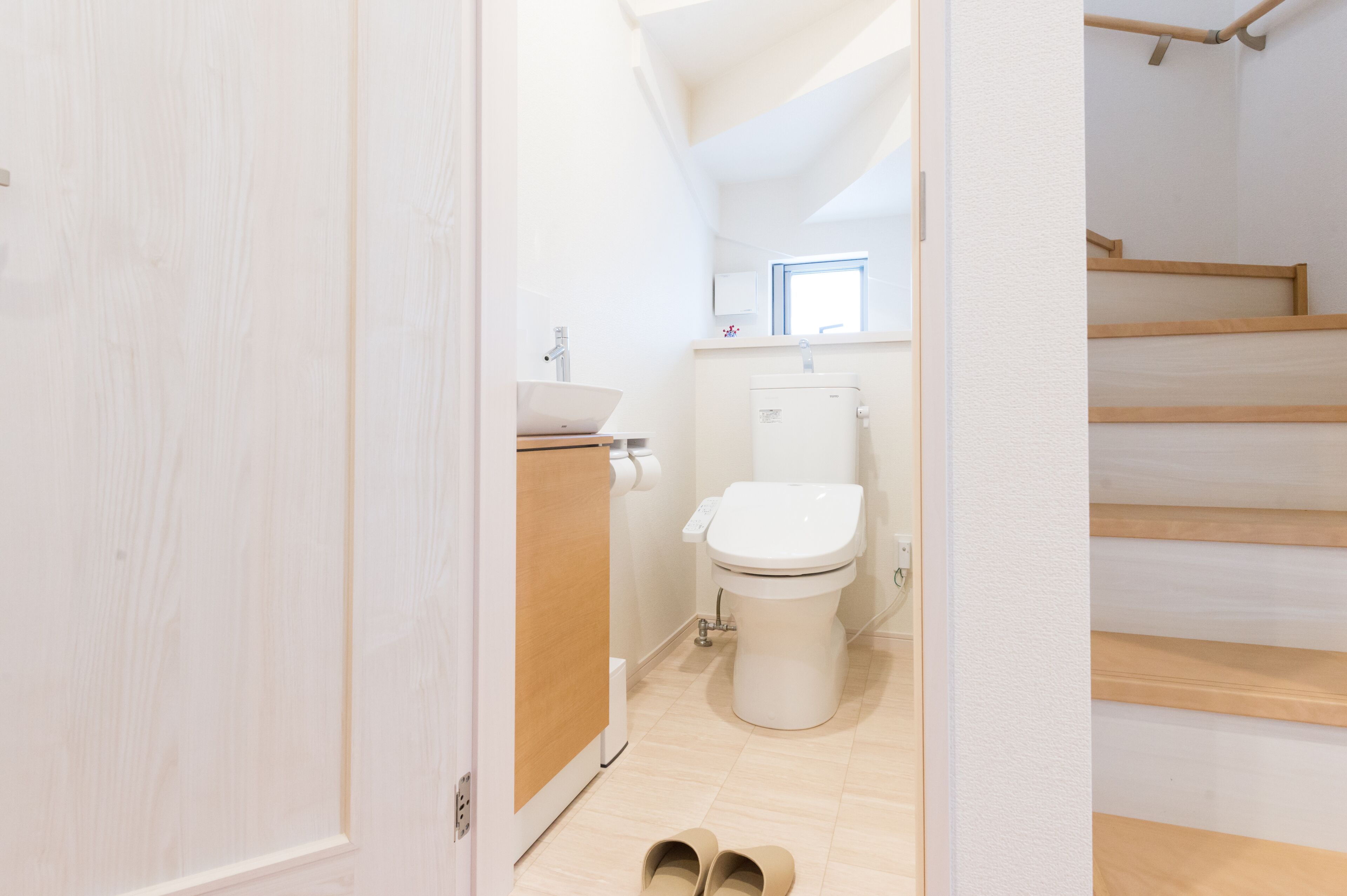 Une salle de bain moderne avec des toilettes, un lavabo et un revêtement de sol en bois.