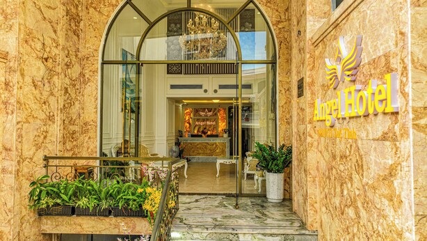 The exterior of Angel Hotel with a marble facade, a reception desk, and a chandelier visible through the glass entrance. - Angel Hotel Nha Trang (Nha Trang)