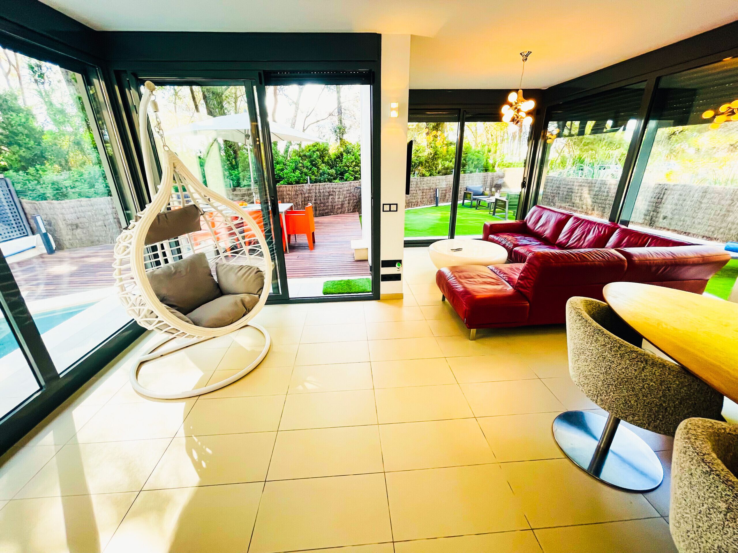 This is an area of ​​the living room designed to really relax. You have a wonderful cozy hanging chair and a large comfortable couch. Both are surrounded by large glass windows overlooking the garden.