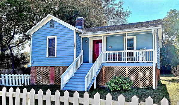 A two-story house with a blue exterior, a red door, and a small porch with a white railing. - Immaculate Cottage in the Historic District. Quiet street, large fenced yard. (Washington)