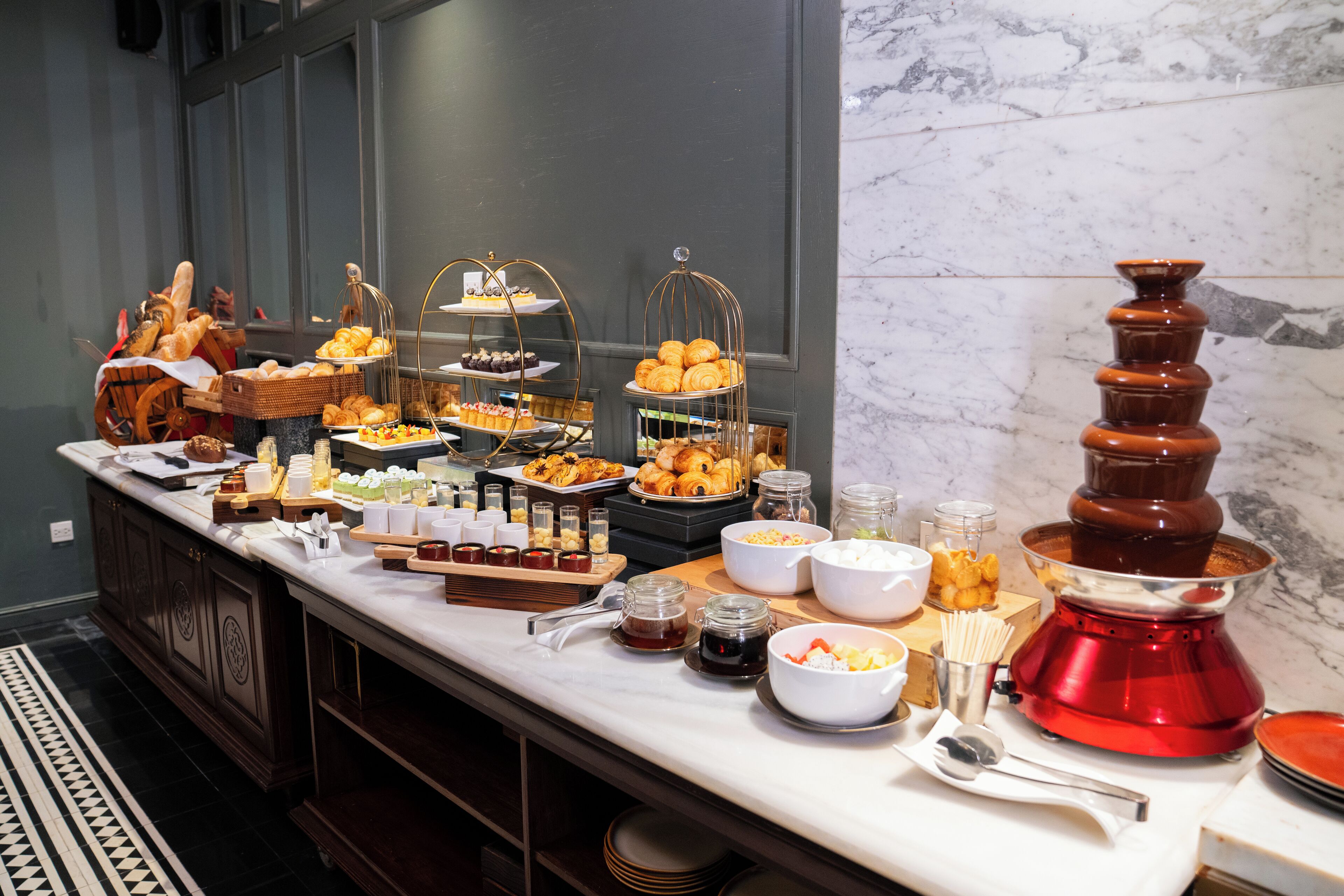 A buffet with various food items and a chocolate fountain.
