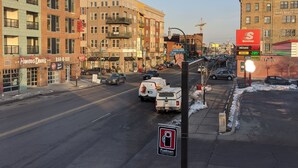 Eine Stadtstraße mit Gebäuden, Autos und einer Aral-Tankstelle.