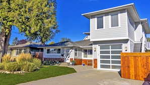 A two-story house with a garage, a tree in the front yard, and a wooden fence. - LOCATION LOCATION LOCATION! IMMACULATE 1 BEDROOM SUITE-ULTRA PRIVATE AND UNIQUE! (Victoria)