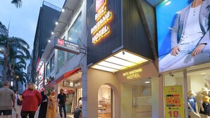 A hotel with a prominent sign, a large digital display, and a storefront with mannequins. - Bitz Bintang Hotel (Kuala Lumpur)