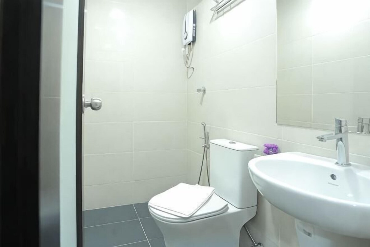 A bathroom with a toilet, sink, and mirror.