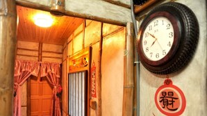 Un interior de madera con un reloj de estilo japonés tradicional y una puerta con cortina.