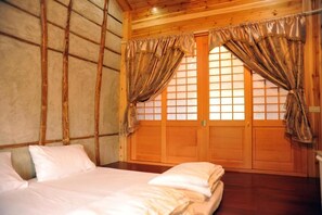 A wooden room with a bed, a window with a view, and a door. - Fengnan Tianzhuang Homestay (Fuli)