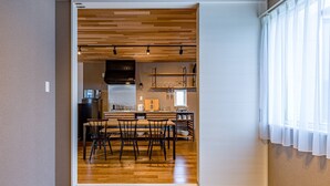 A modern kitchen with wooden flooring, a dining area with chairs, and a built-in oven. - Rakuten STAY HOUSE x WILL STYLE Fujinomiya (Fujinomiya)