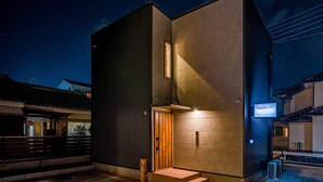 A modern building with a dark facade, a wooden door, and a sign indicating a 'Rooftop Stay' with a 'Wildstyle' theme. - Rakuten STAY HOUSE x WILL STYLE Fujinomiya (Fujinomiya)