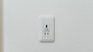 Un enchufe blanco con puerto USB en una pared con textura.