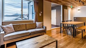 A modern interior with a wooden floor, a sofa with cushions, a dining table with chairs, and a bench. - Rakuten STAY HOUSE x WILL STYLE Fujinomiya (Fujinomiya)