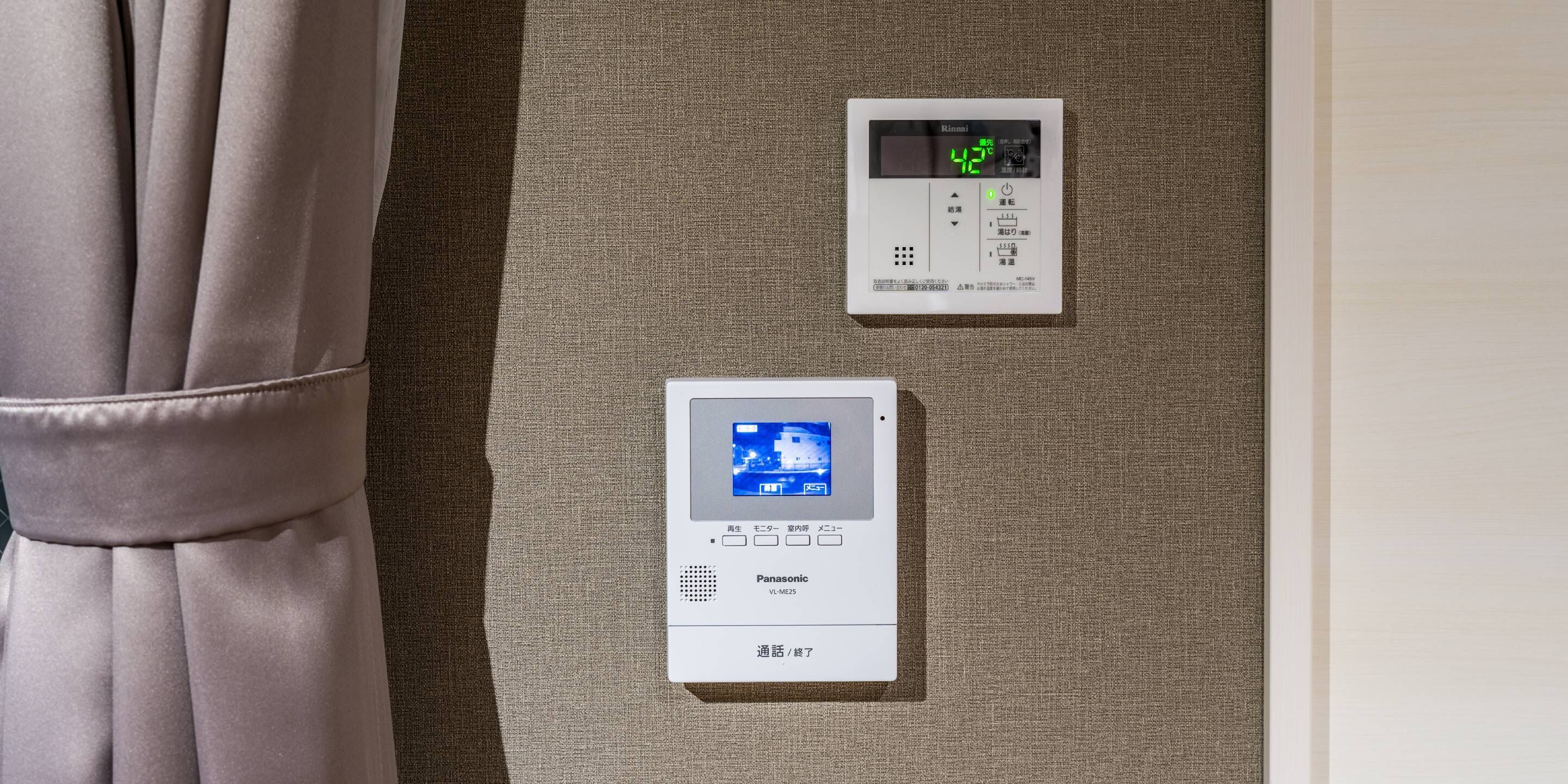 A control panel with a digital display and a remote control, likely for room amenities.