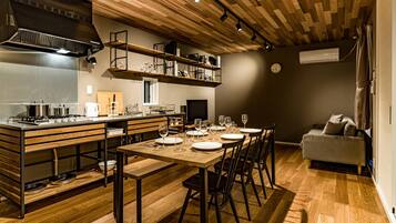 A modern kitchen with wooden cabinetry, a built-in stove, and a dining area with a wooden table and chairs.