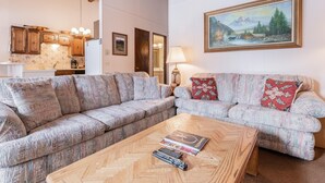 Un salón con sofá, mesa de centro y un cuadro en la pared.
