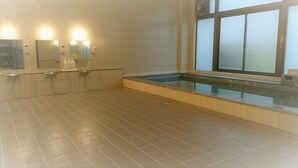 A bathroom with a glass-enclosed hot tub, a tiled floor, and a mirror with lights above it. - Hotel New Otsuka (Shirako)