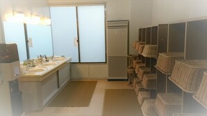A bathroom with three sinks, a mirror, a heater, and wicker baskets on shelves. - Hotel New Otsuka (Shirako)
